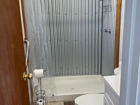 Newly remodeled bathroom shower and floor, new toilet and sink and mirror.