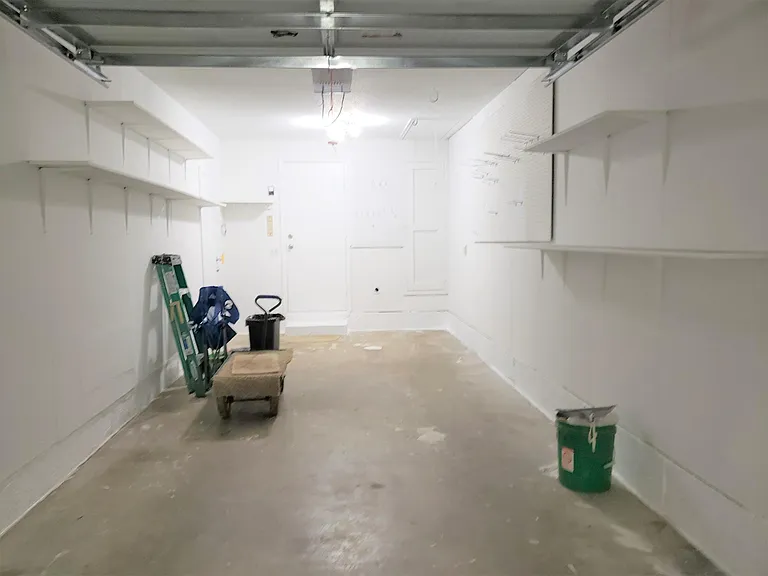 Garage with storage shelves and automatic garage door opener.