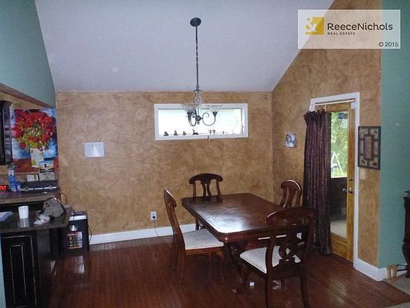Vaulted Dining room with hardwoods & access to a screened porch.