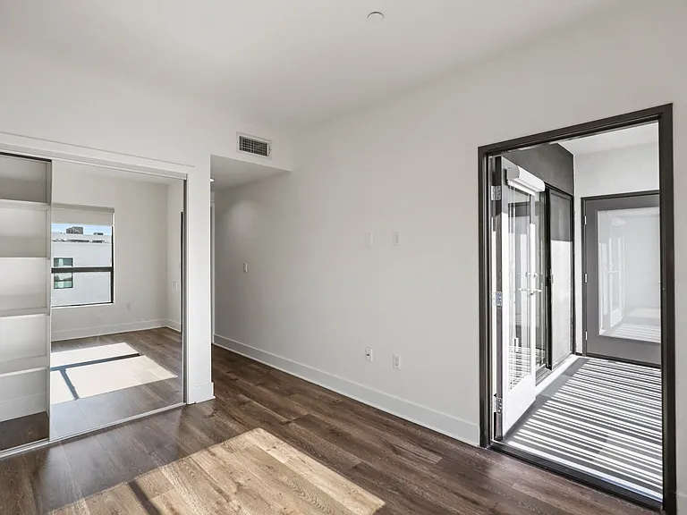 Bedroom with Mirrored Closet with Built-In Shelving and Patio