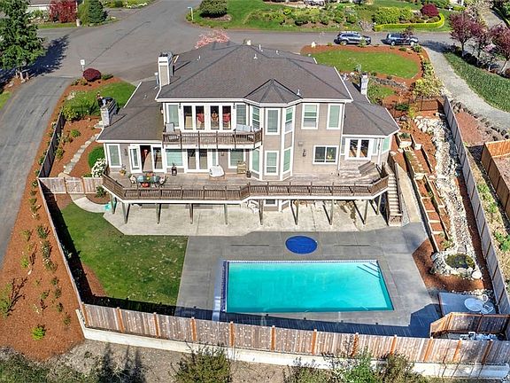 Aerial view of the shy half acre lot, gorgeous pool, hot tub and waterfall feature in the back yard. 