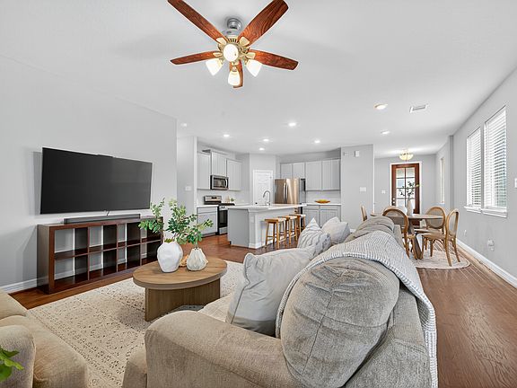Open Living Area Spacious and light-filled living room with rich wood floors and an open layout that flows effortlessly into the kitchen and dining spaces.