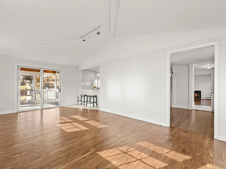 Family room with vaulted ceiling, sliders to screened in porch and deck.