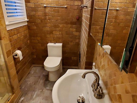 Renovated Bathroom:: Tiled Walk-in Shower, Frameless Sliding Shower Door, Inlay Basin Vanity, Bulkhead Light Fixtures, Brushed Stainless Conduit