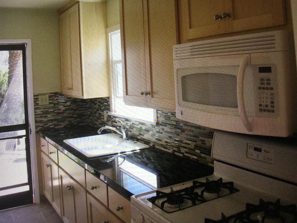 Natural wood ash cabinets, stove, microwave and refrigerator