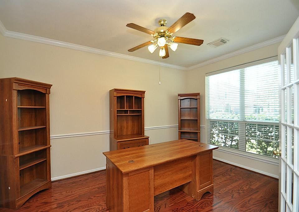 Study: hardwood floors, crown moldings, chair railing  & French doors