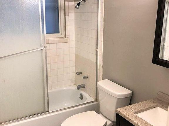 bathroom with new toilet, vanity, and mirror