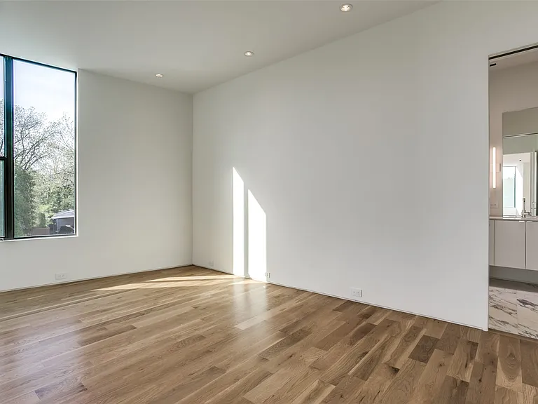 Spacious interior featuring wood-finish flooring, recessed lighting, and a large black-framed window