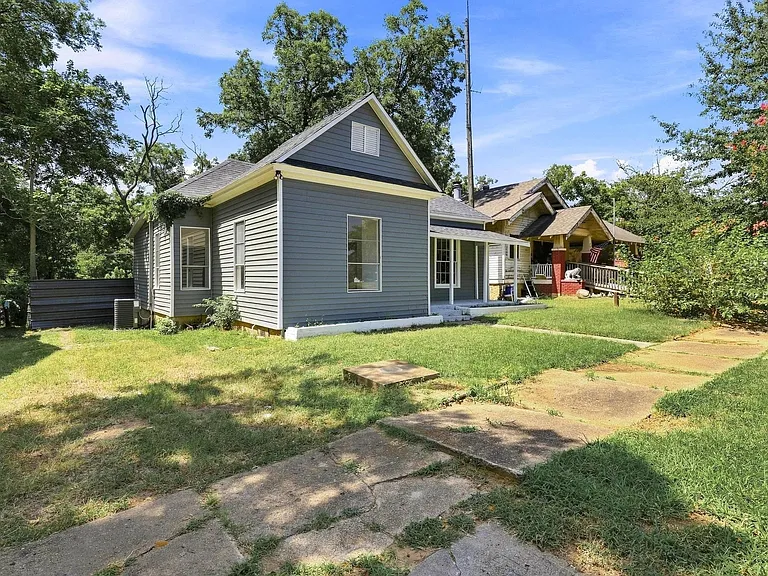 Charming exterior featuring gray siding, white trim, and a covered front porch with white columns