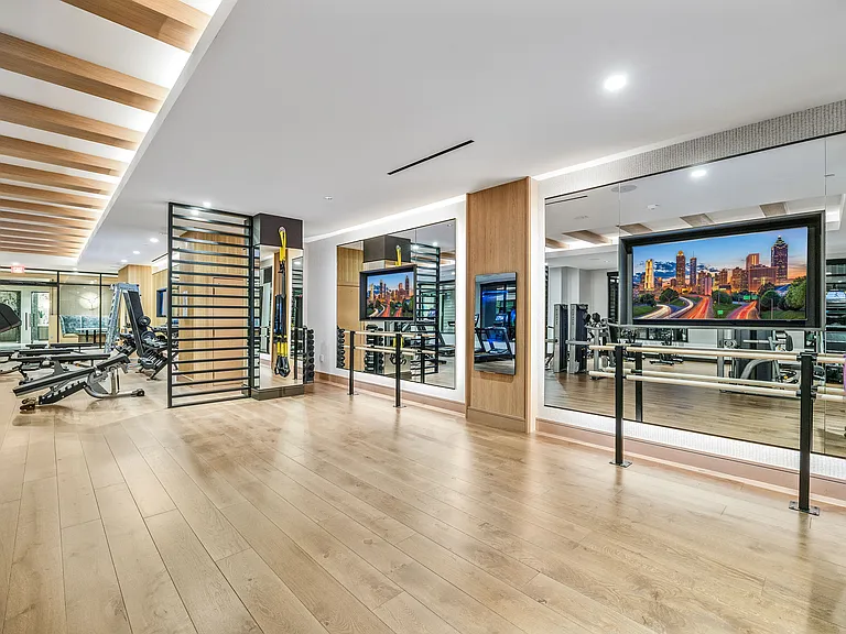 Luxurious and modern gym with state-of-the-art equipment, mirrored walls, and bright lighting, perfect for fitness enthusiasts.