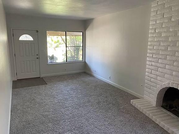 Spacious living room with rustic brick fireplace
