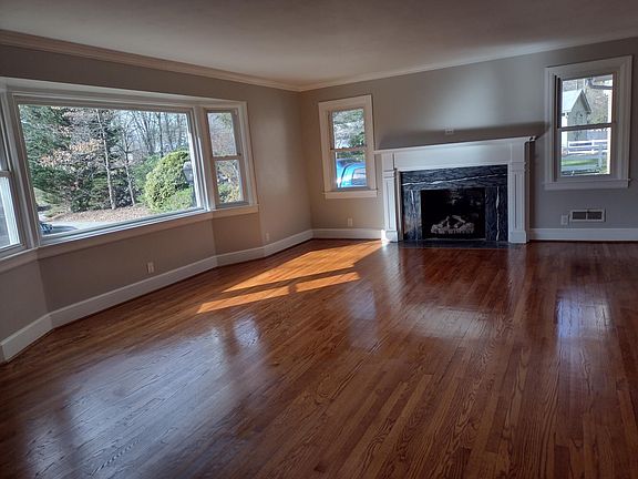 Light filled living room with bay window and gas logs
