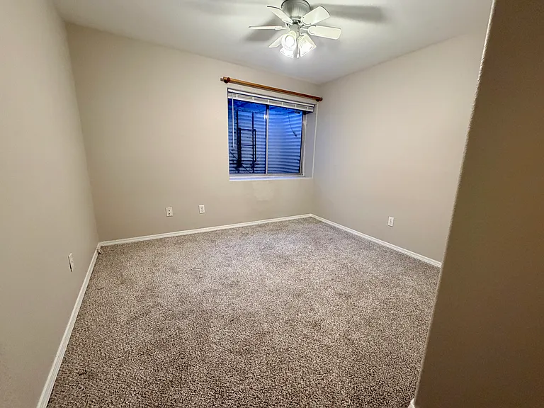 Comfortable third bedroom featuring natural light, sliding double closet doors, and easy access to the adjacent updated full bathroom and laundry area.