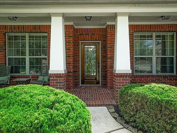 Walk up to the brick front porch with a beautiful lead & beveled glass front entry door