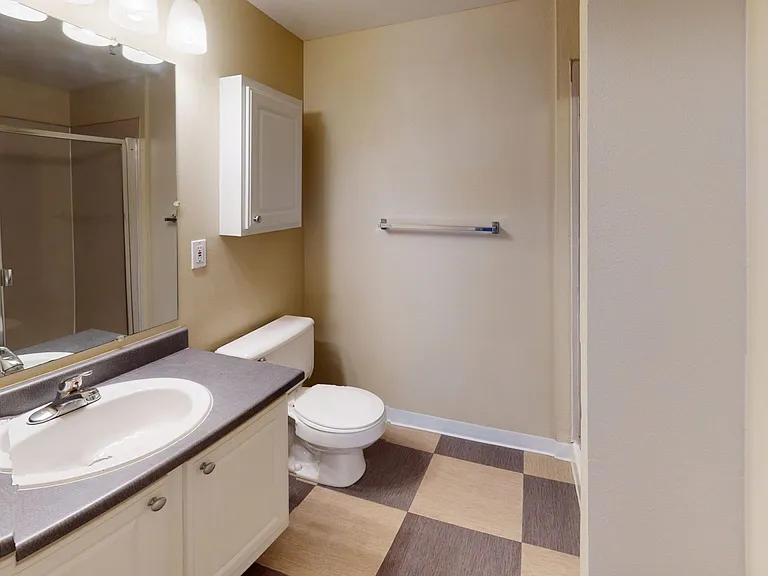 Apartment bathroom with tile flooring.