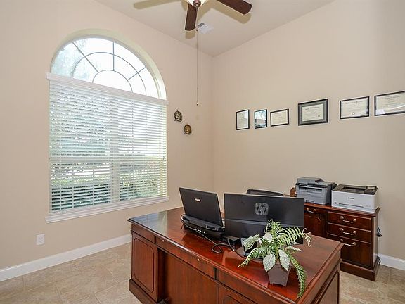 This handsome study has plenty of room for multiple desk or comfortable office furniture. High ceilings, large window, soft neutral wall paint and carpeted flooring illustrate this room perfectly.