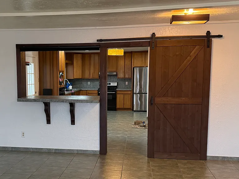 The entertainment room has a stylish barnyard door and breakfast nook that face into the kitchen/diningroom.