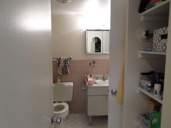 Bathroom with built-in shelves & entrance from hallway