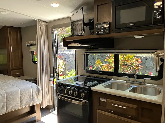 Kitchenette with 3-burner cooktop and oven, microwave, double sink