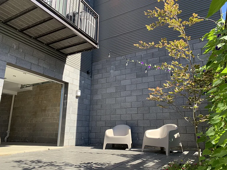 Out back is a private courtyard with strung lights, landscape, and seating.