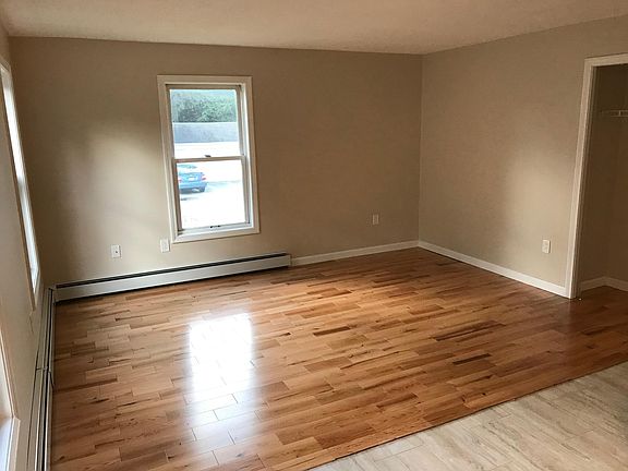 Living room off of the kitchen with new hardwood floors. Closet shown to the right.