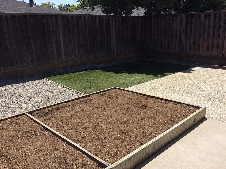 Backyard with a raised bed, which is currently covered over.