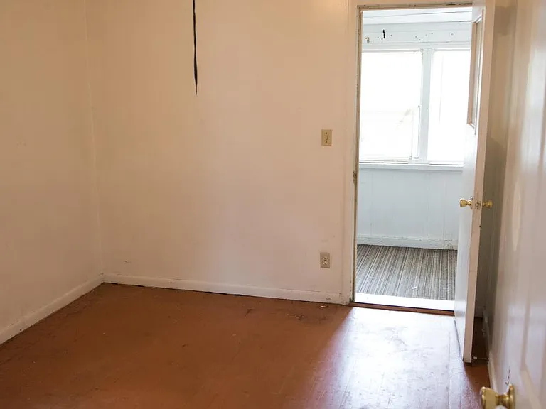Bedroom with enclosed porch overlooking back yard