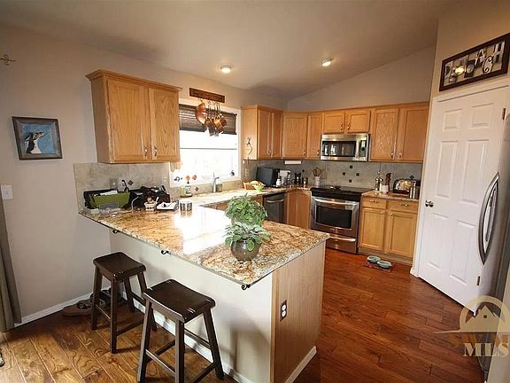 Kitchen with stainless steel appliances and granite countertops and railroad hardwood flooring
