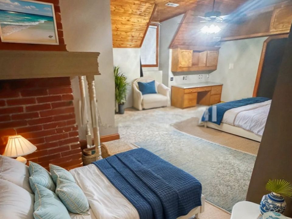 large bedroom with original brick, high vaulted ceilings, LED lighting & upgraded fixtures, ceiling fan, built-in shelves, study, custom cabinets, vanity, walk-in closet, full bathroom with plenty of storage space.