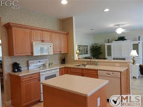 Kitchen features corian counters, integrated sink, convenient island, plenty of cupboards and pantry.  Newly-installed side by side refrigerator.