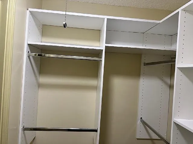 Plenty of shelving and hanging rods in walk-in bedroom closet for your wardrobe. Rods and shelves are adjustable.