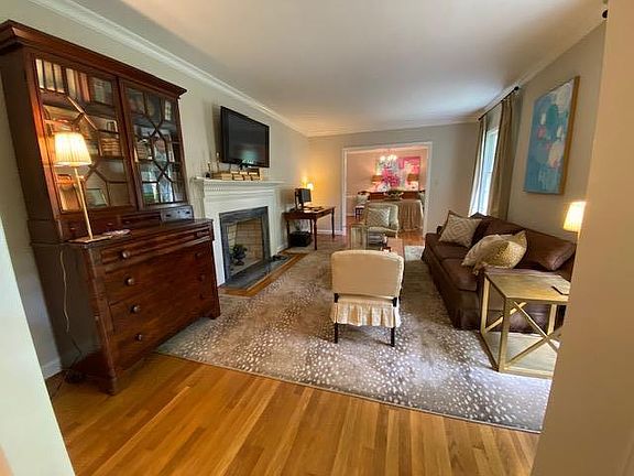 Formal living room with wood burning fireplace. This home is only listed through Zillow and its affiliates.