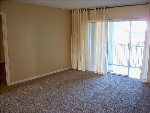 Living room with sliders to the covered screened tiled balcony