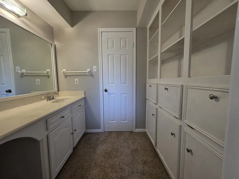 Shared / guest bathroom: featuring tons of built-in cabinets & vanity.