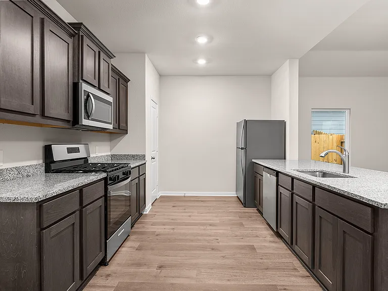 The kitchen has wood cabinetry and stainless-steel appliances.