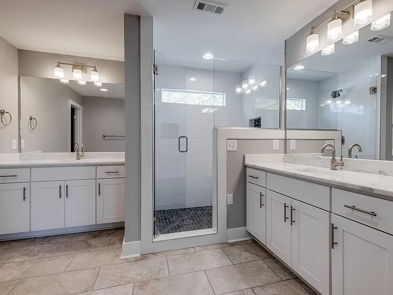 Primary bath with two separate sinks and walk in shower with bench