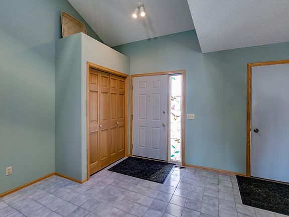 Large open entry with vaulted ceiling and skylight.  Neutral tile through out entry and kitchen.