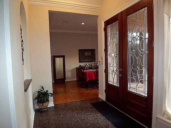 Elegant entry offering double beveled glass front doors, granite flooring, raised ceilings and double crown molding.