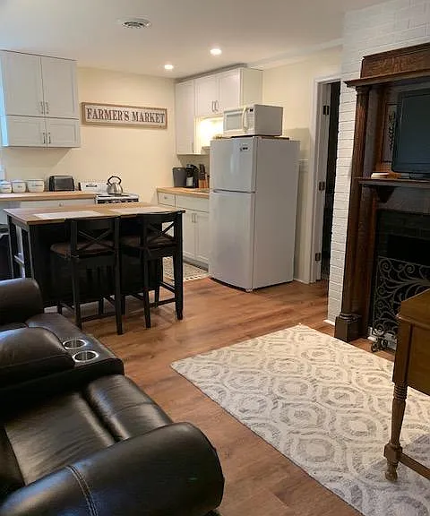 Combined kitchen, eating area and living room with electric fireplace.