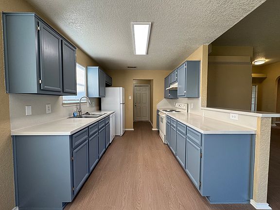 Freshly painted shaker cabinets, extended counter space, and a deep sink make meal prep a pleasure.