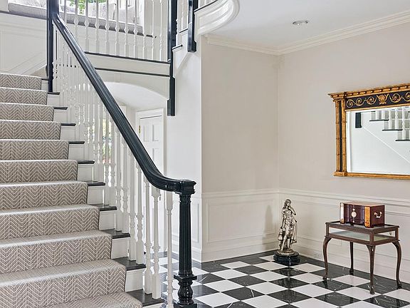Grand front-to-back formal entrance hall with sweeping staircase.