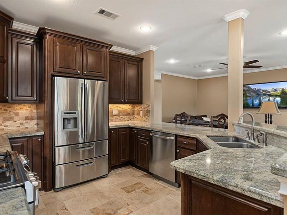 Custom finishes adorn this kitchen overlooking all living spaces. Under-mount kitchen sink makes it a chefs dream.