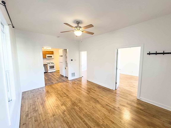 Living room with doors open to both bedrooms and looking towards the kitche