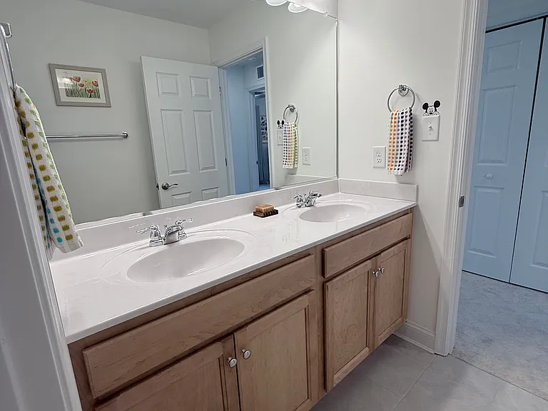 2nd level bathroom with double sink and separate shower/toilet area.