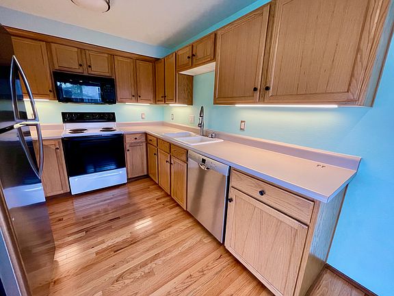 Kitchen with nice pull-down faucet, new Bosch dishwasher, large fingerprint-resistant stainless steel fridge, and dimmable under-cabinet lighting. Microwave fan over stove vents to the outside.