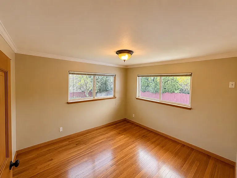 First bedroom with hardwood floors crown molding, big windows, fresh paint, and large closet.