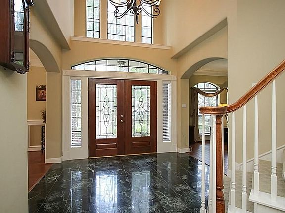 LIGHT & BRIGHT 2-STORY ENTRY WITH LEAD GLASS WOOD DOORS. A soaring 2 story entry with soon to have porcelain tile floors and an elegant wrought iron chandelier. Newly stained doors with a wall of windows at the entry. COME SEE THE NEW BEIGE PORCELAIN