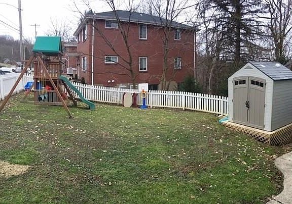 Side yard with playset and shed.  Additional shed behind home.
