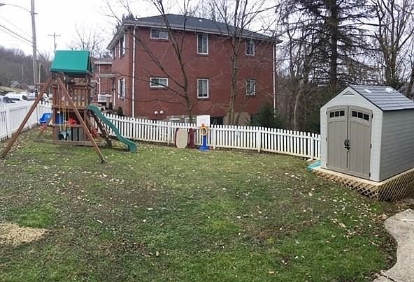 Side yard with playset and shed.  Additional shed behind home.
