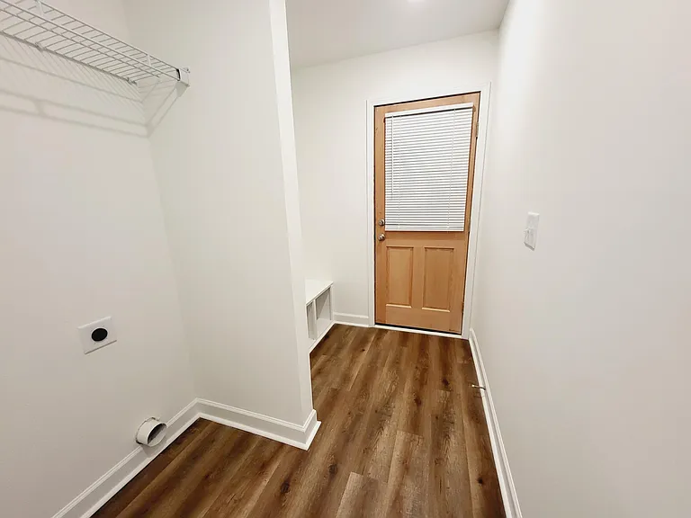 Washer and dryer area with a mud room space, has cubbies and hooks.